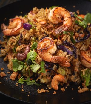 Grilled shrimp salad on a black plate and black background